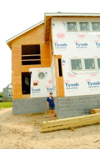 Allie stands next to a new home construction in Lewes, Delaware that is building up on several feet of freeboard.