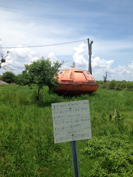 A protest sign in the bayou reads: "It's worth saving." Gulf residents are losing land at a rapid rate.