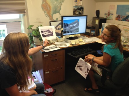 Road tripper Kirsten Howard and Lisa McKeon of USGS compare historical photos of glaciers with current ones.