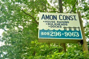 A roadside billboard advertises house raising services